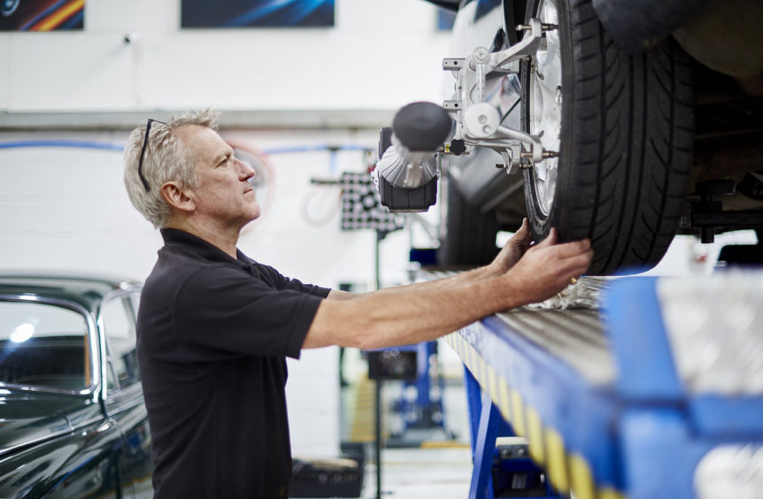 Barny checking a wheel on the four-wheel alignment rig